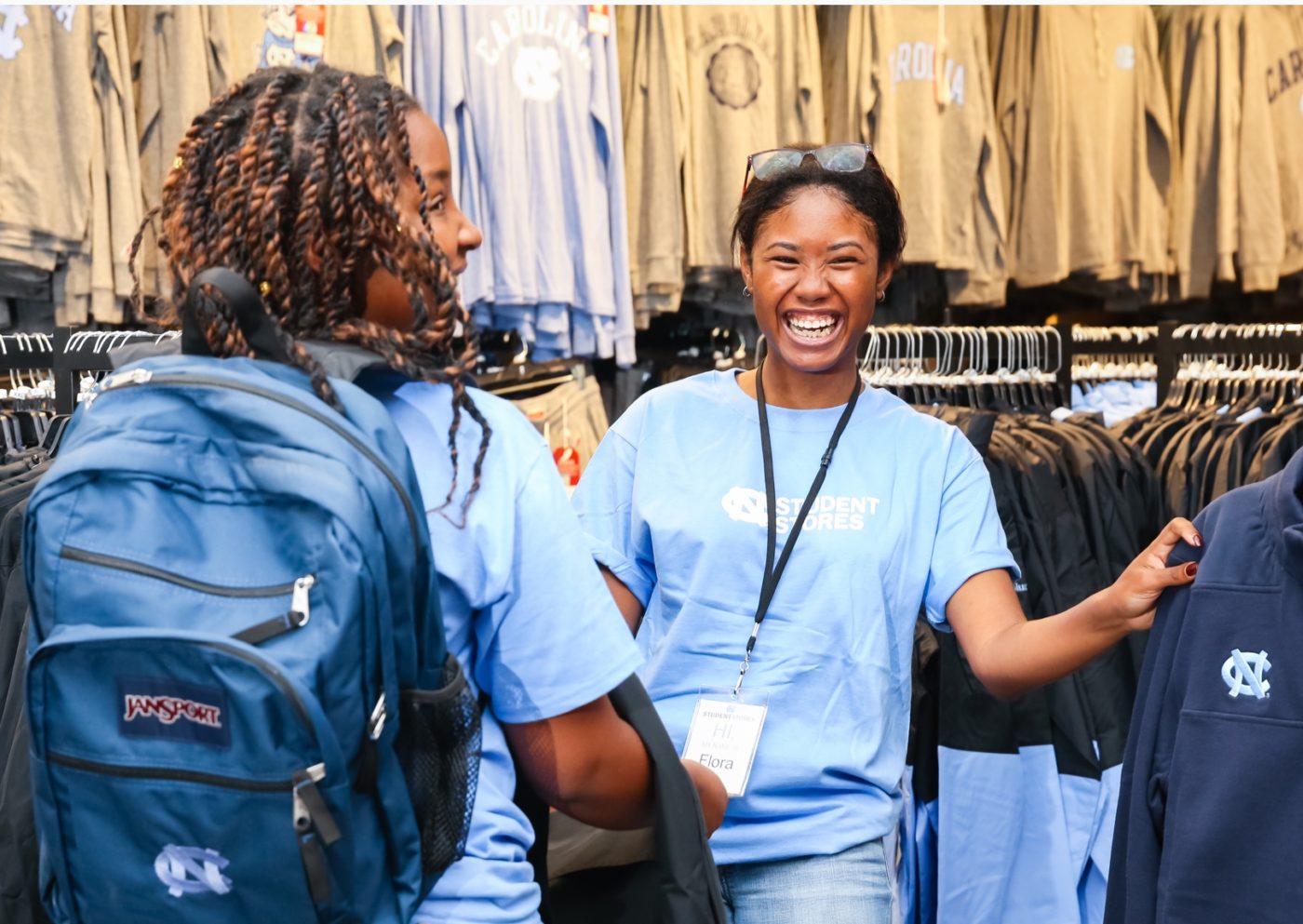 Excited students showing off campus merchandise, include backpacks and t-shirts