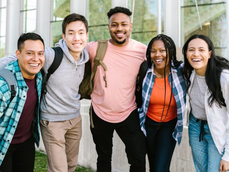 five students staying together outside the school building