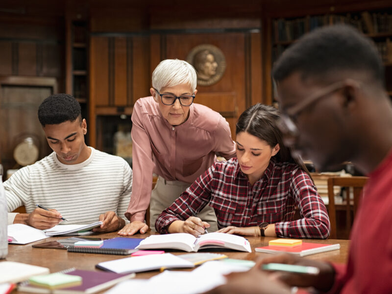 university students studying with teacher